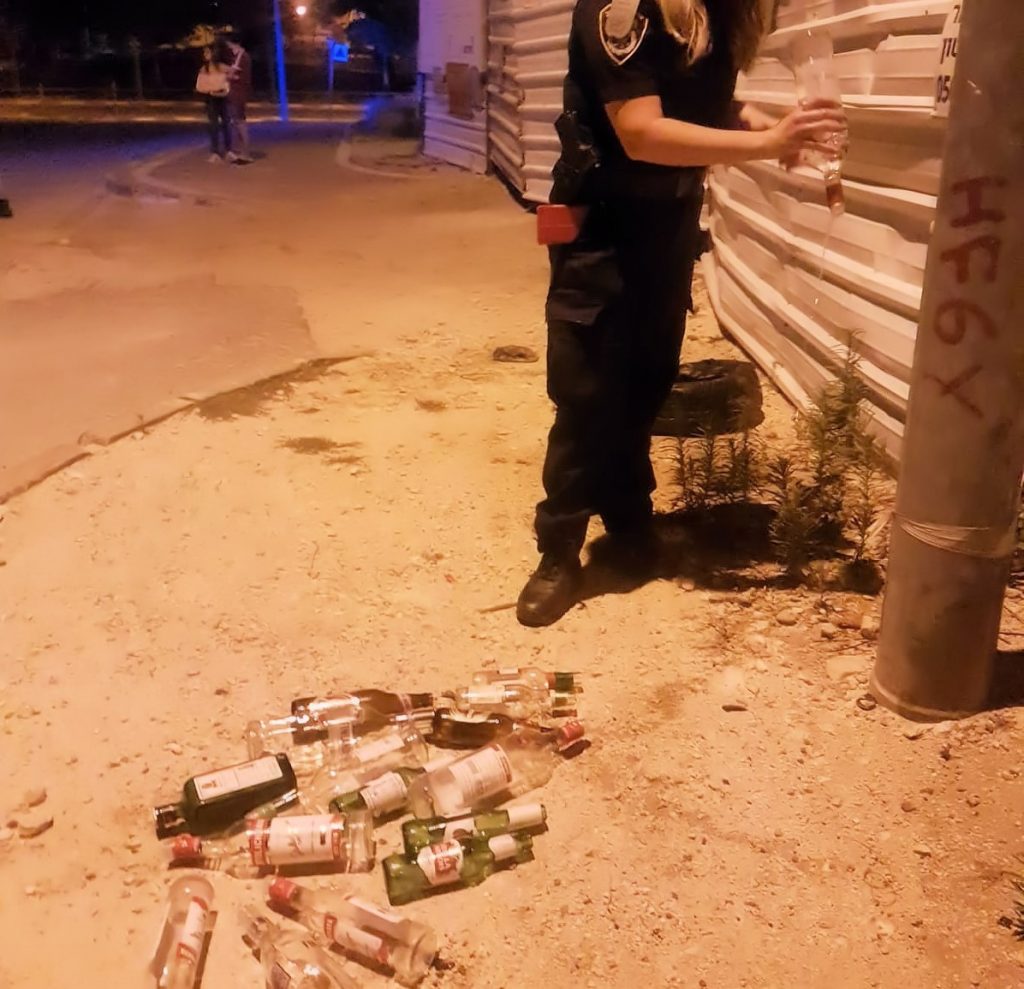 שוטרים שופכים בקבוקי אלכוהול (צילום: דוברות המשטרה)