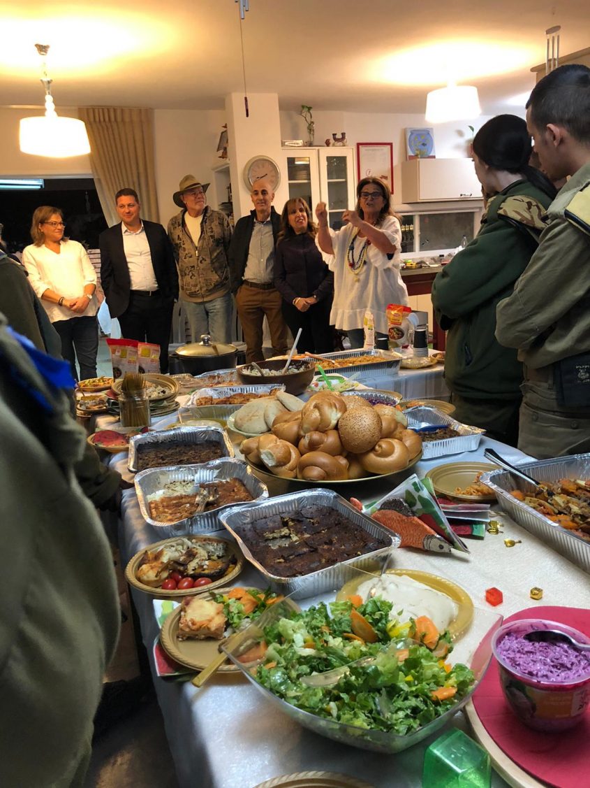 החיילים והמארחים סביב השולחנות (צילום: פרטי)