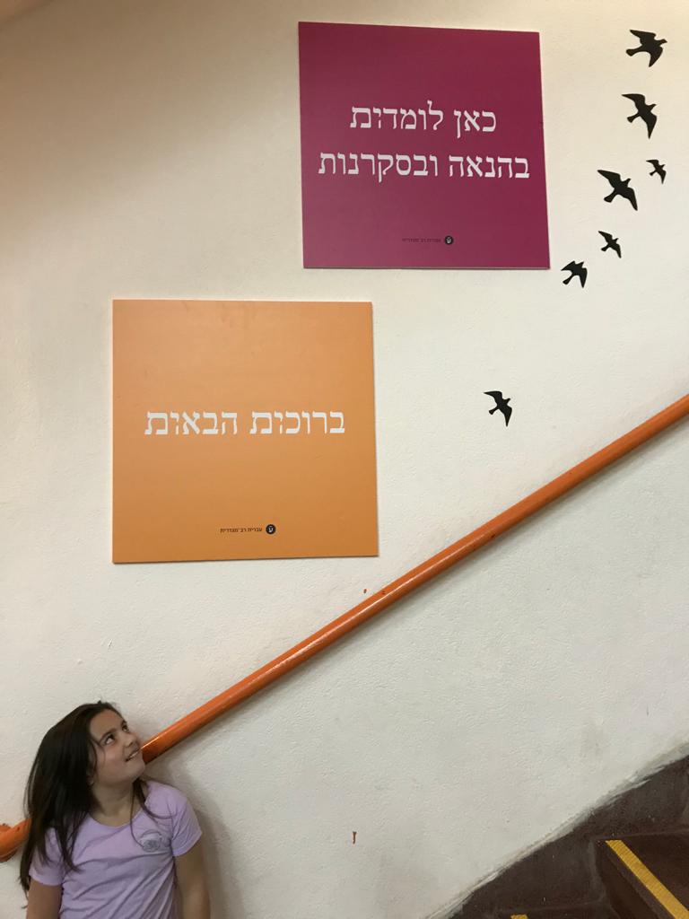 אביגיל אלקובי עם השלטים הרב מגדריים (צילום: יניב אלקובי)