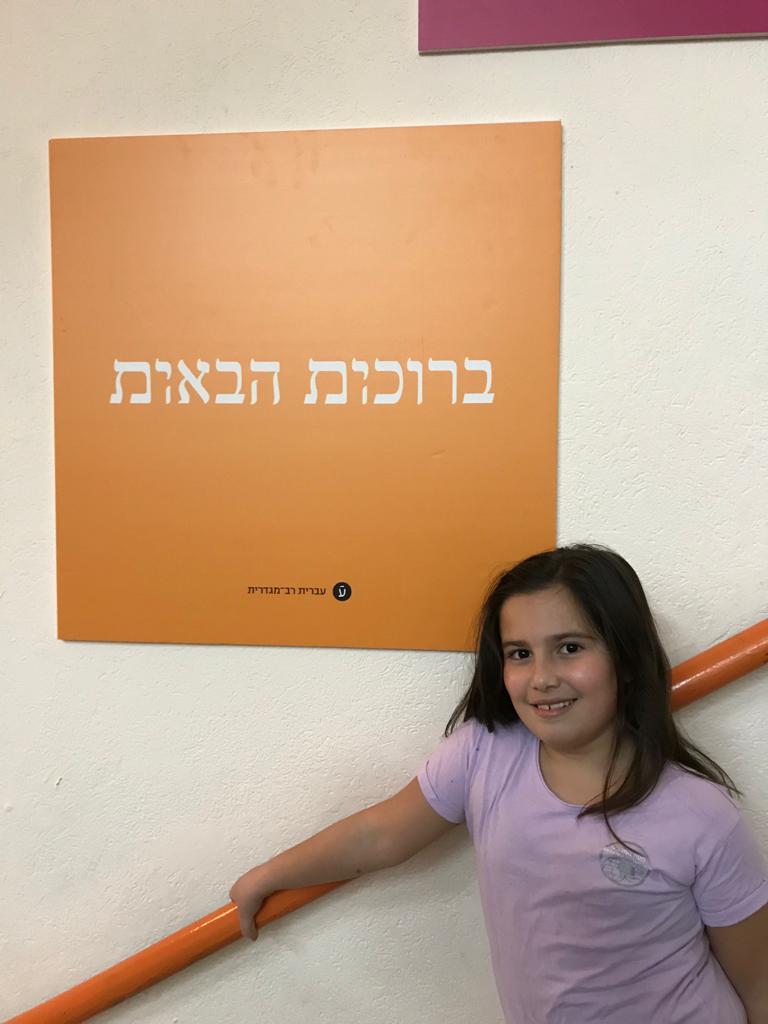 אביגיל אלקובי עם השלטים הרב מגדריים (צילום: יניב אלקובי)